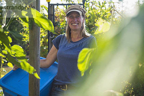 Porträt selbstbewusster lächelnder Bauer im sonnigen Gemüsegarten