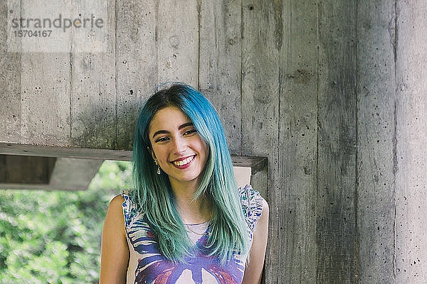 Porträt lächelnde junge Frau mit blauem Haar
