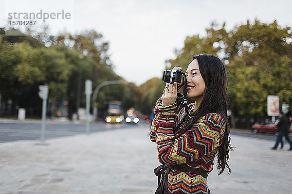 Weibliche Touristin mit Kamera auf einer Stadtstraße