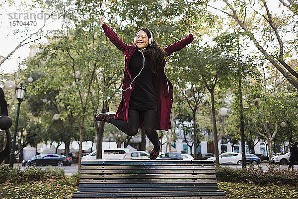 Porträt spielerische überschwängliche Frau springt von städtischen Stadt Bank