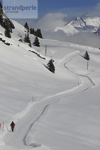 Schneeschuhläufer auf einem sonnigen  verschneiten Bergweg  Vals  Kanton Graubünden  Schweiz