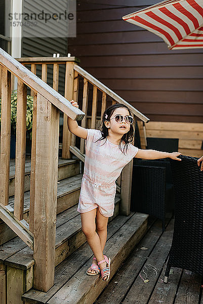 Kleinkind mit Sonnenbrille auf der Treppe posierend
