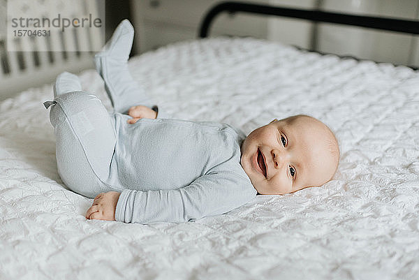 Kleiner Junge lächelt im Bett