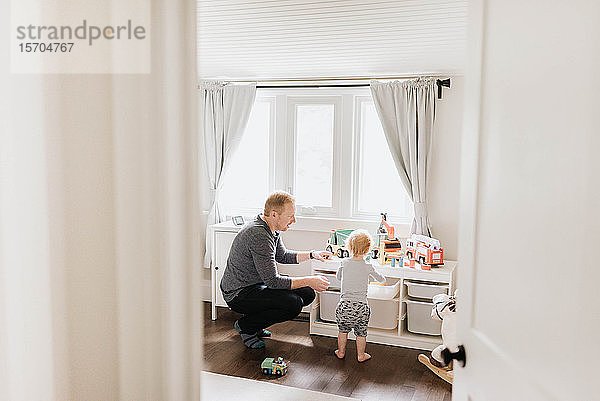 Vater spielt mit Sohn im Schlafzimmer