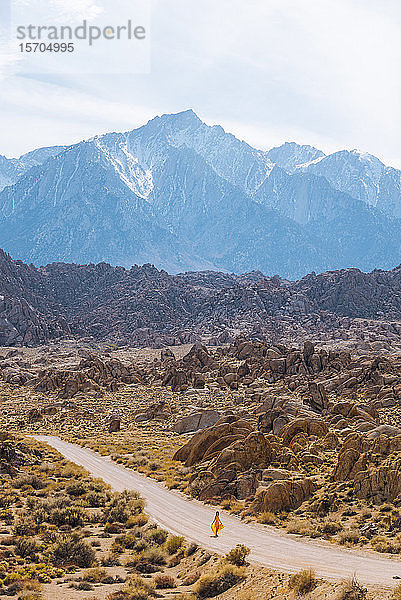 Frau in gelbem Kleid spaziert durch die Alabama Hills  Kalifornien  USA