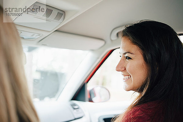 Nahaufnahme einer lächelnden Frau  die ihren Freund im Auto sitzend anschaut