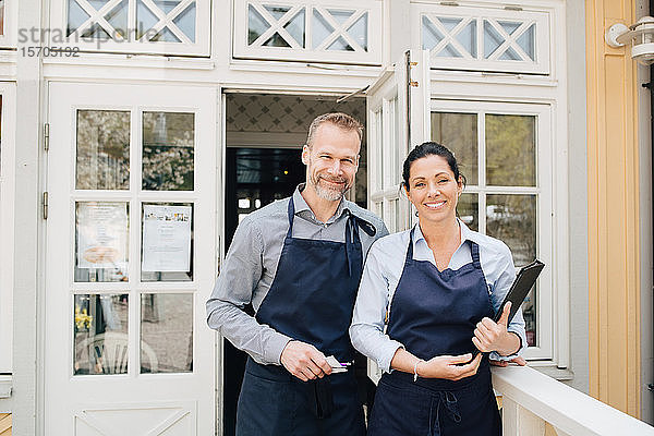 Im Freien stehende männliche und weibliche Restaurantbesitzer