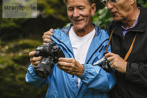 Älterer Mann zeigt einem männlichen Freund während eines Fotokurses Kamera