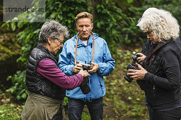 Ältere Frauen und Männer  die die Kamera während des Fotokurses benutzen