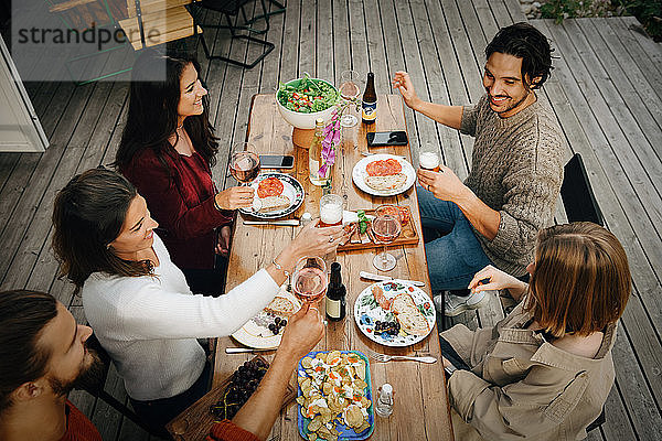 Schrägaufnahme von Freunden  die während der Gartenparty Getränke genießen  während sie essen