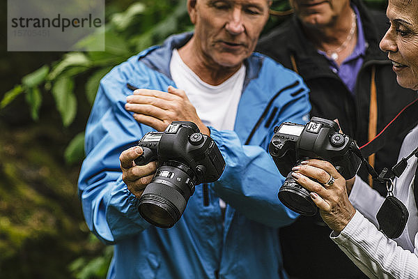 Älterer Mann zeigt einer Ausbilderin während eines Fotokurses die Kamera
