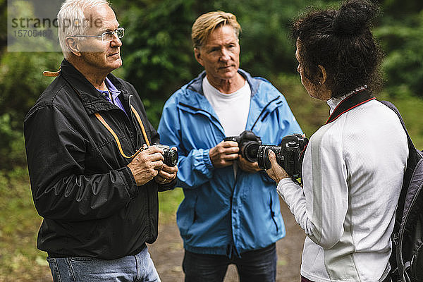 Ältere Männer hören einer Ausbilderin während eines Fotokurses zu