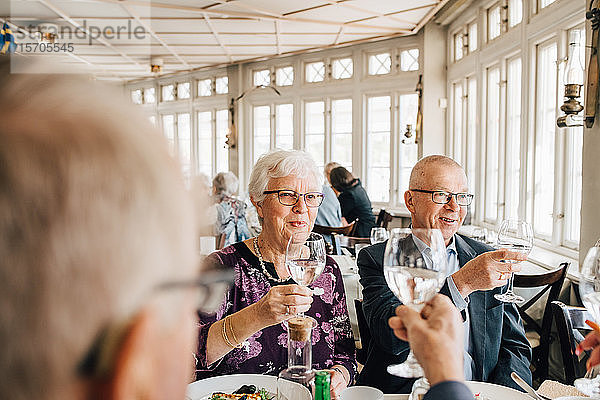 Ältere Freunde beim Weinglas-Toast im Restaurant