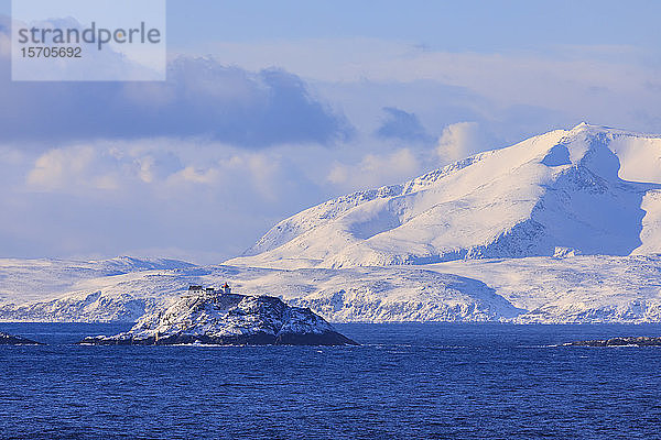 Leuchtturm  Norwegische See  spektakuläre schneebedeckte Berge im Winter  Troms-Inseln  Polarkreis  Nordnorwegen  Europa