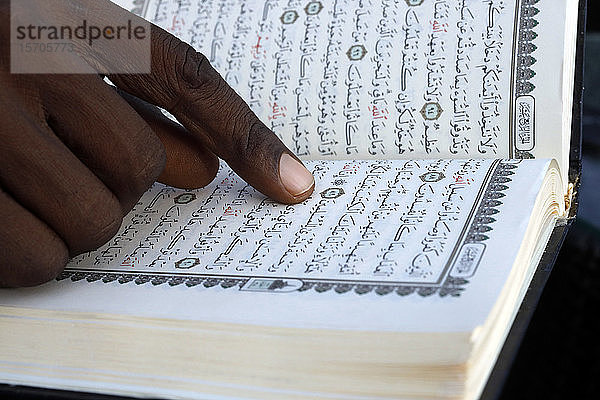 Nahaufnahme der Hände eines afrikanischen muslimischen Mannes  der den Koran liest  Togo  Westafrika  Afrika