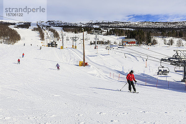 Bjorli Dorf  Skifahrer  Piste und Sessellift  Frühschnee-Skigebiet  Wintersonne  Gudbrandsdalen Tal  Oppland  Norwegen  Skandinavien  Europa