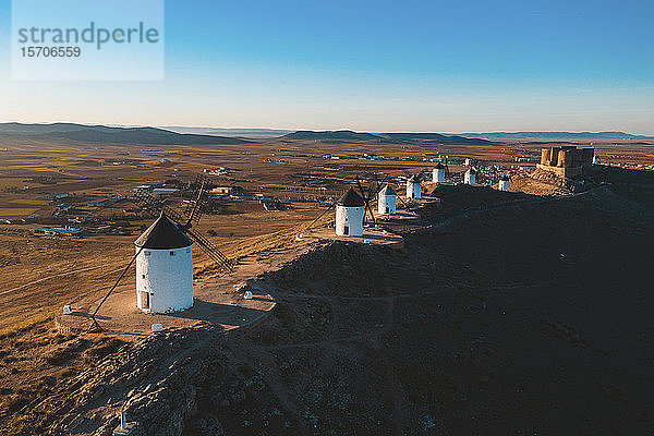 Spanien  Provinz Toledo  Consuegra  Reihe alter Windmühlen auf dem Gipfel eines braunen Hügels