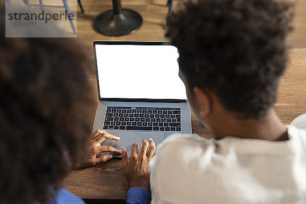 SchülerInnen benutzen Laptop für ein Projekt in einem Café