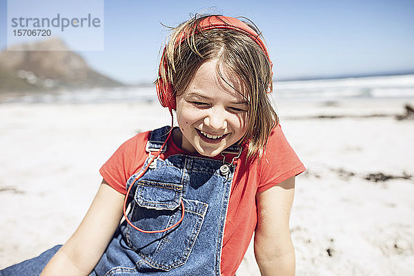 Glückliches Mädchen hört Musik mit Kopfhörern am Strand Kapstadt  Western Cape  Südafrika