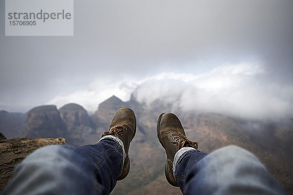 Mann mit einem Paar alter Stiefel auf dem Gipfel eines Hügels mit Blick auf den nebligen Blyde River Canyon  Südafrika