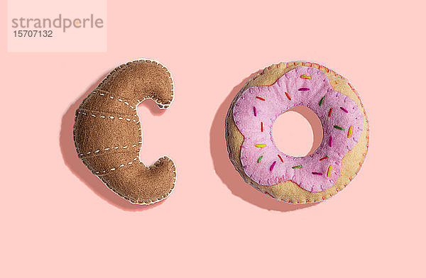3D-Illustration  Plüschimitat-Croissant- und Donut-Muster auf hellrosa Hintergrund