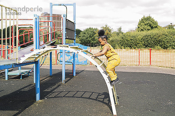Mädchen klettert auf einem Spielplatz eine Leiter hoch