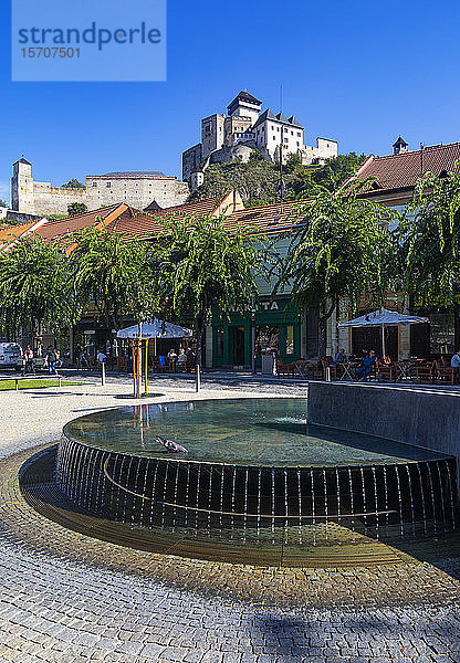 Slowakei  Trencin  Brunnen auf dem Friedensplatz mit der Burg Trencin im Hintergrund
