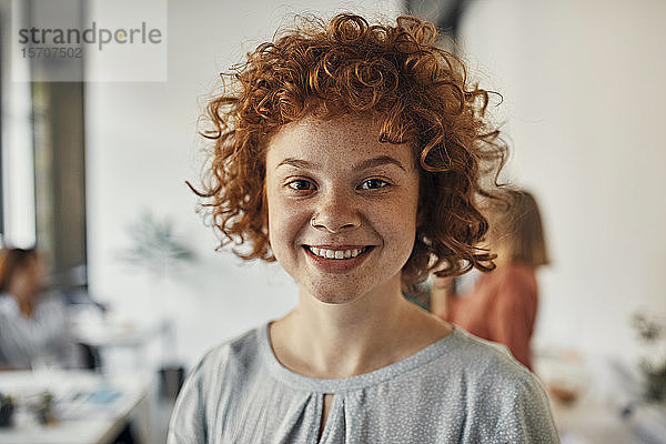 Porträt einer lächelnden rothaarigen Geschäftsfrau im Amt