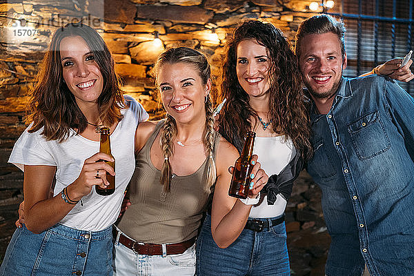 Gruppenporträt von glücklichen Freunden im Freien in einem Steinhaus bei einer Party