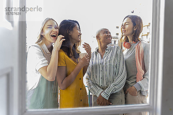 Vier glückliche Frauen stehen auf dem Balkon
