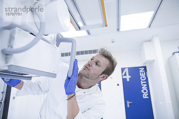 Radiologe beim Einstellen eines Röntgengeräts in einem Krankenhaus