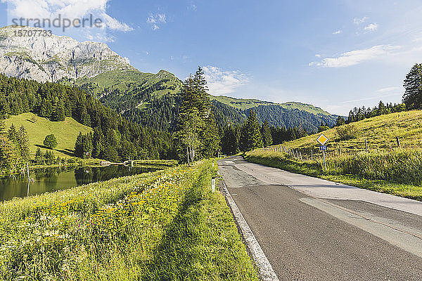 Österreich  Kärnten  Blick auf eine leere Straße im bewaldeten Tal der Karnischen Alpen im Sommer