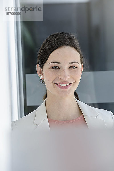 Porträt einer lächelnden jungen Geschäftsfrau im Amt