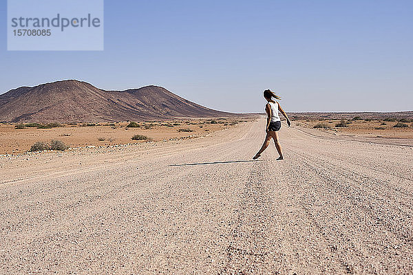 Frau  die mitten auf einem Feldweg geht  Damaraland  Namibia