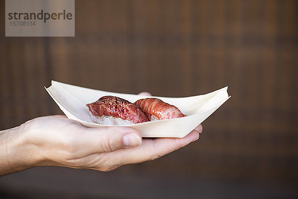 Japan  Hand einer Frau  die ein Tablett mit japanischem hida-Rindfleisch hält