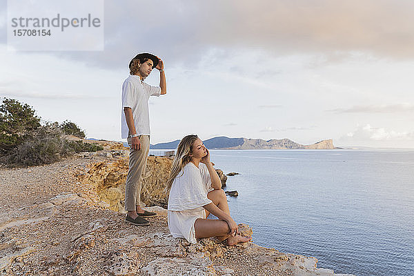 Junges Paar vor dem Meer mit Blick in die Ferne  Ibiza  Balearen  Spanien