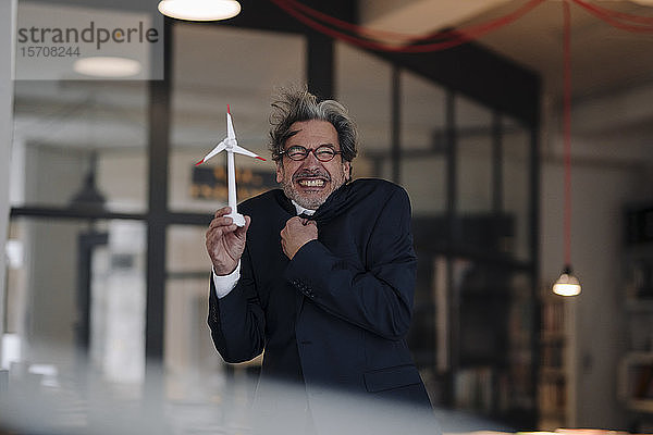 Einfrieren eines leitenden Geschäftsmannes  der ein Windturbinenmodell im Amt hält