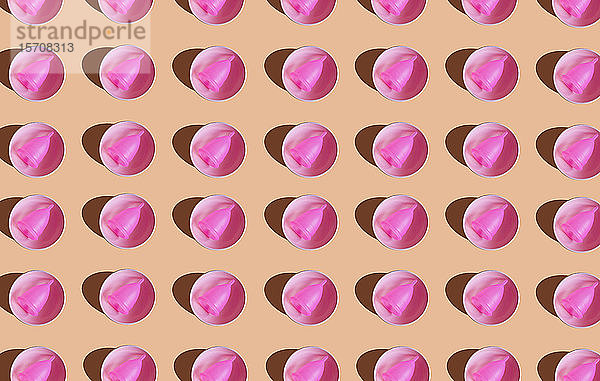 3D-Illustration  Reihe einer rosa Menstruationstasse in einer Keramikschale auf cremefarbenem Hintergrund