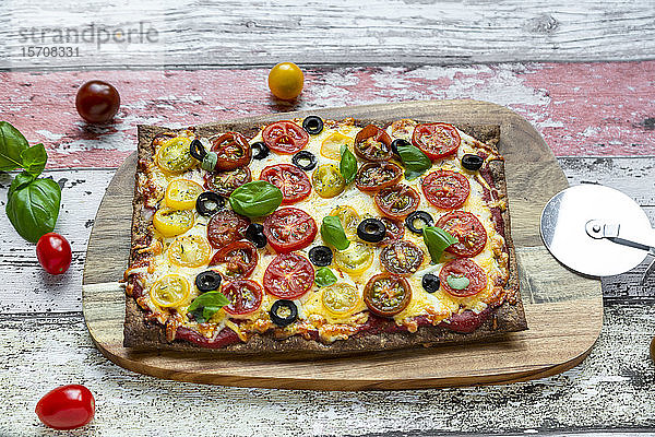 Leinsamenpizza mit wenig Kohlehydraten  Käse  Kirschtomaten  Oliven und Basilikum