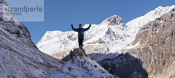 Bergsteiger jubelt auf dem Gipfel eines Felsens  Dhaulagiri Circuit Trek  Himalaya  Nepal