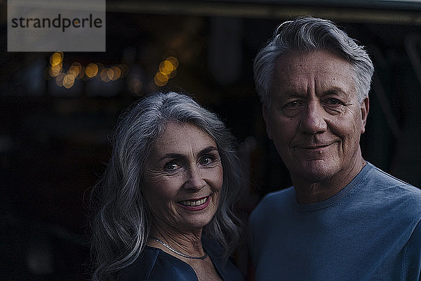 Porträt eines lächelnden älteren Paares im Freien bei Nacht