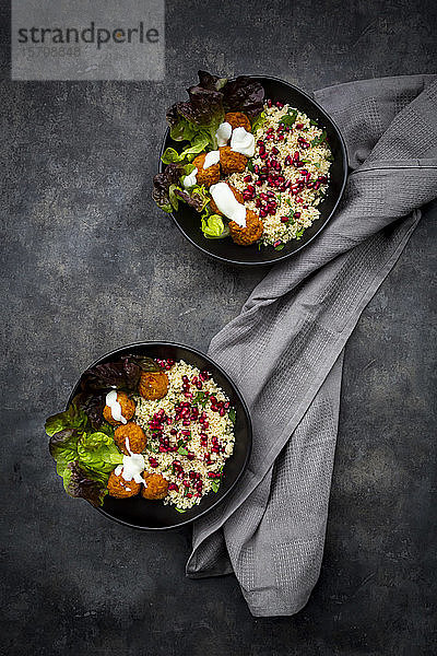 Schalen Falafel mit Salat  Joghurt  Granatapfelkernen  Petersilie  Minze und Tabbouleh-Salat