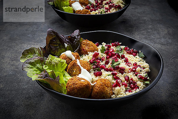Schalen Falafel mit Salat  Joghurt  Granatapfelkernen  Petersilie  Minze und Tabbouleh-Salat
