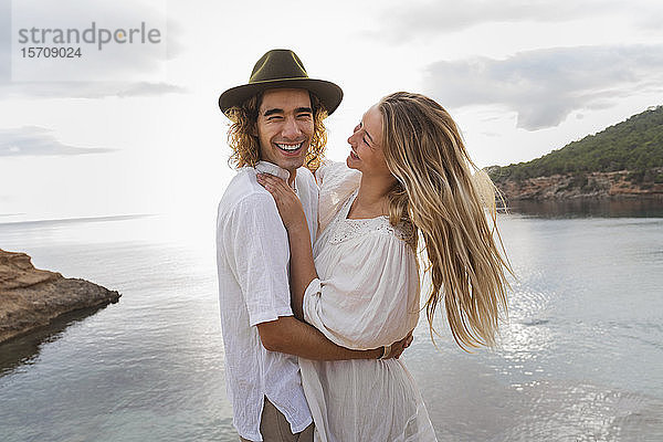Porträt eines jungen verliebten Paares vor dem Meer stehend  Ibiza  Balearen  Spanien