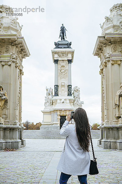 Frau beim Fotografieren des Alfonso-XII-Denkmals im Park El Retiro  Madrid  Spanien