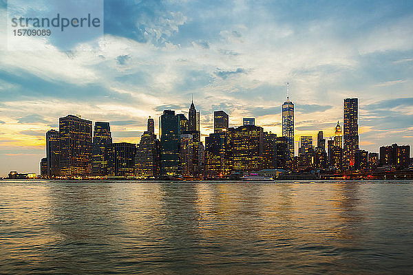 USA  New York  New York City  Skyline von Manhattan in der Abenddämmerung beleuchtet