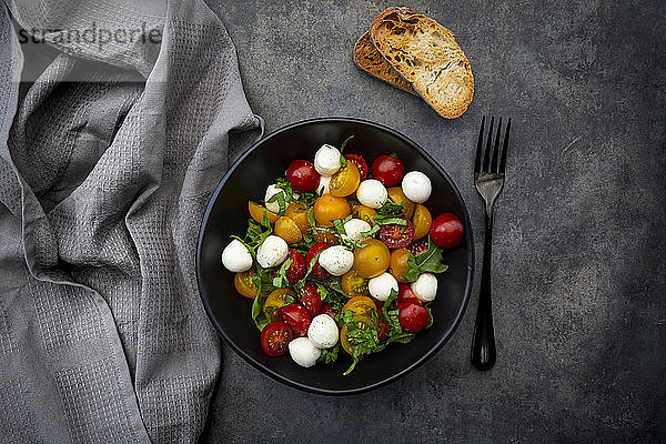 Draufsicht auf Salat mit Rucola  Mozzarella  Kirschtomaten und Basilikum