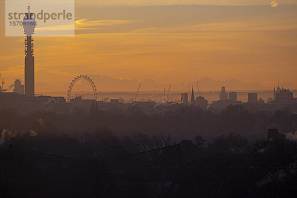 Großbritannien  England  London  Silhouetten von BT Tower  London Eye und umliegenden Gebäuden bei orangefarbenem Sonnenaufgang