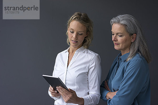 Zwei Geschäftsfrauen schauen gemeinsam auf die Tablette