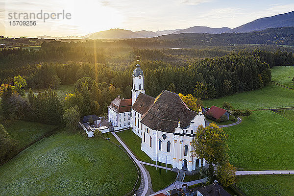 Deutschland  Bayern  Oberbayern  Pfaffenwinkel  Wies  Luftaufnahme der Wallfahrtskirche Wies zum gegeißelten Heiland bei Sonnenaufgang